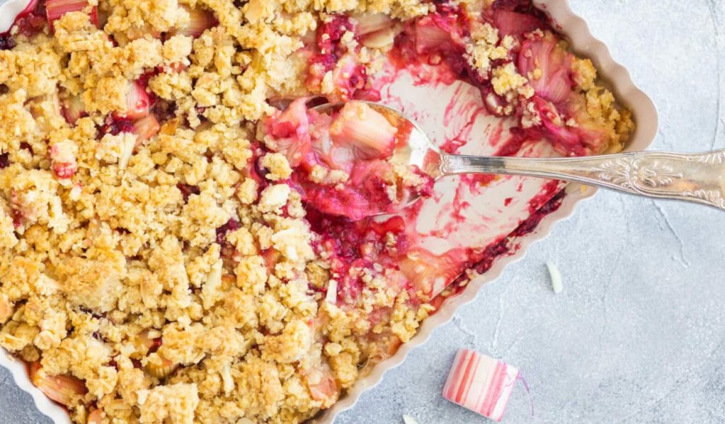 Delicioso crumble com ruibarbo e nozes. Frutas deliciosas assadas sob uma cobertura crocante vão encantar a todos