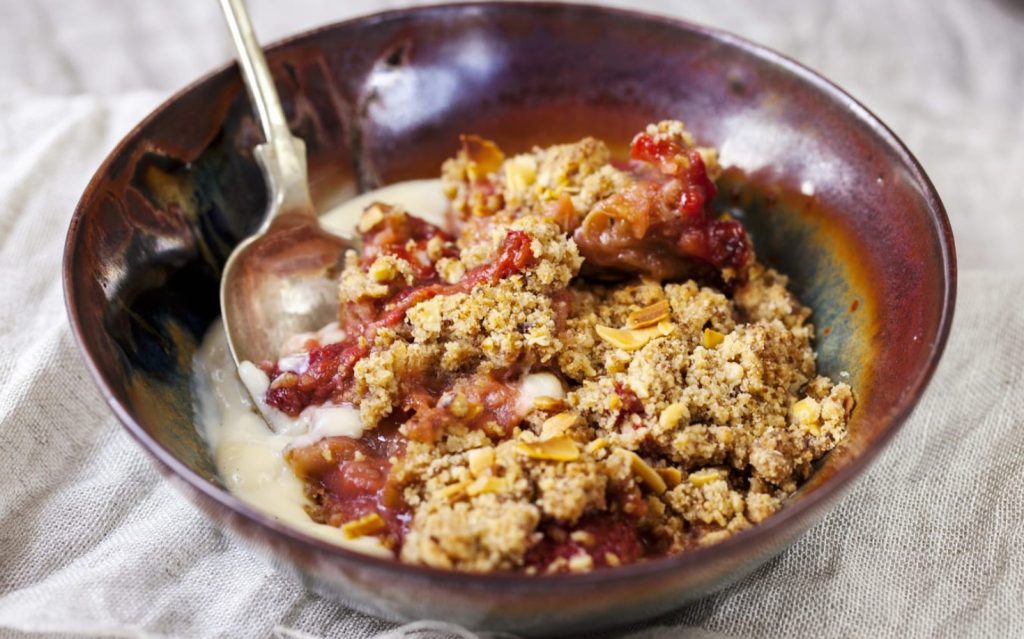 Delicioso crumble com ruibarbo e nozes. Frutas deliciosas assadas sob uma cobertura crocante vão encantar a todos