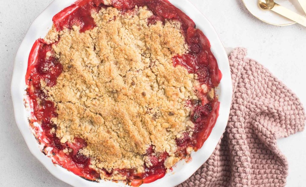 Delicioso crumble com ruibarbo e nozes. Frutas deliciosas assadas sob uma cobertura crocante vão encantar a todos
